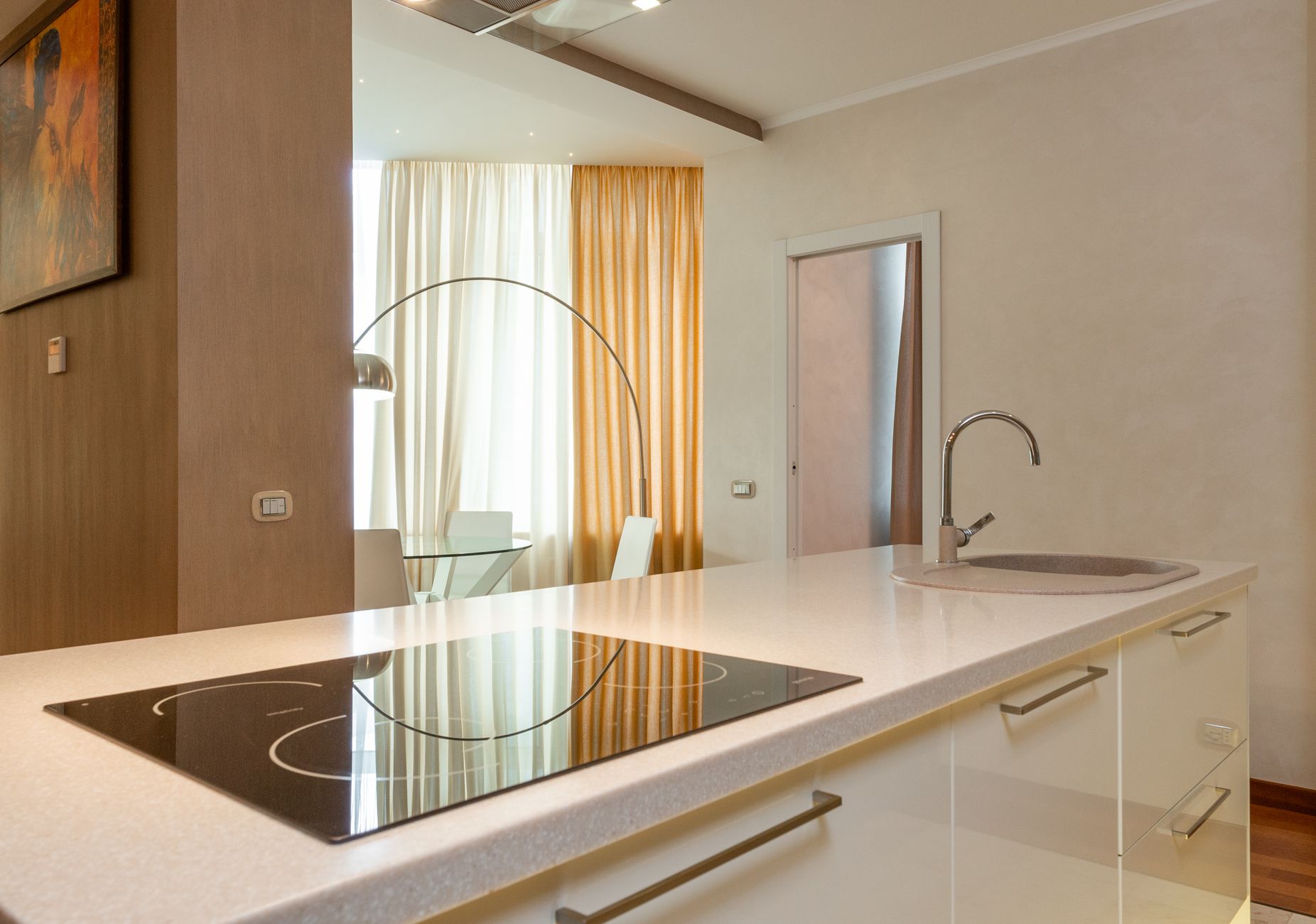 Built in stove and sink with chrome faucet on counter in modern kitchen with dining area in spacious in Riverside, CA